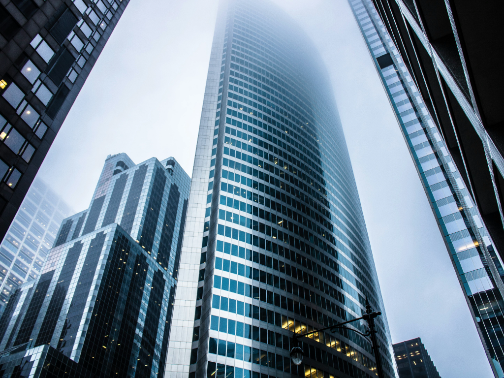 Arranha-céus modernos na cidade de São Paulo com clima de céu nublado, refletindo a arquitetura contemporânea e o ambiente urbano.