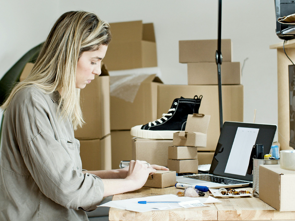 Mulher empacotando produtos em uma loja de comércio.
