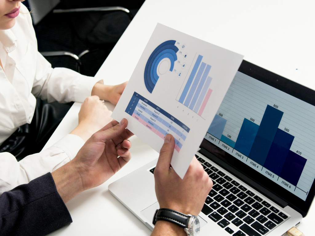 Pessoa apresentando gráficos de análise financeira com dados para preparar seu negócio para vender mais em uma reunião de negócios.